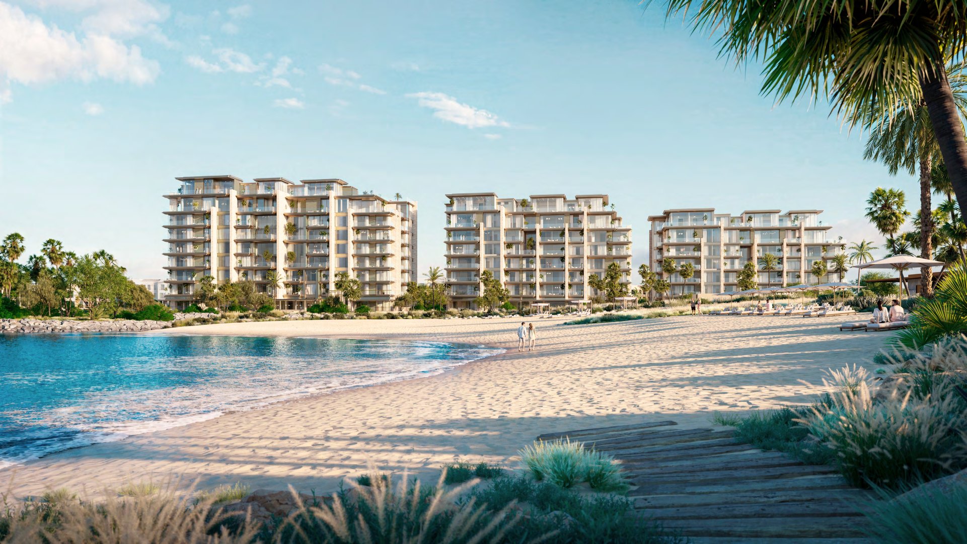 Three Solaya buildings rising behind a white sand beach and calm sea