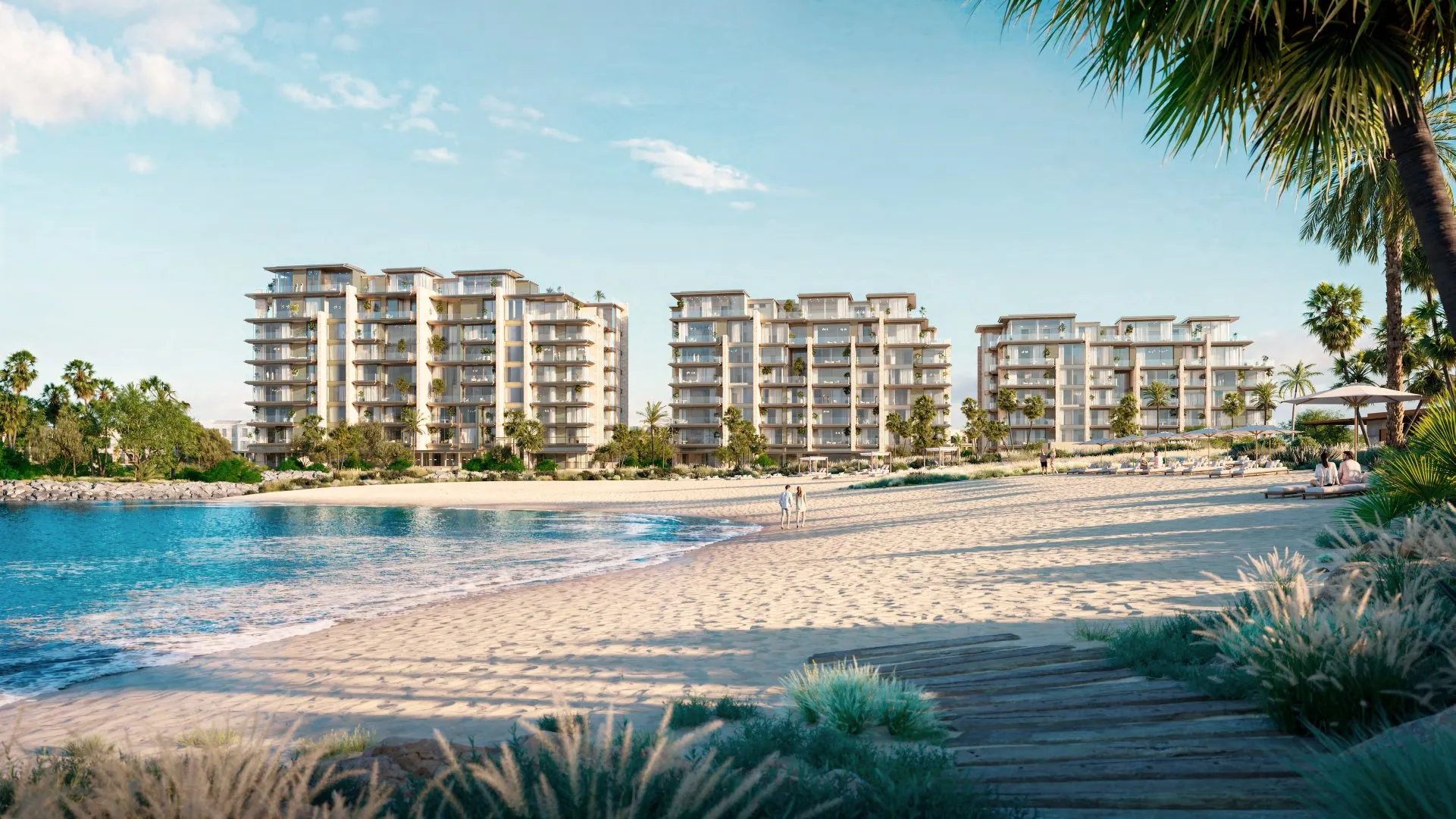 Three Solaya buildings rising behind a white sand beach and calm sea